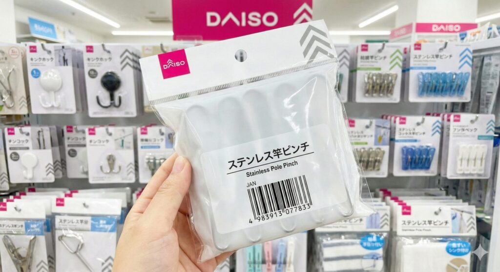 ダイソーの売り場でステンレス竿ピンチを手に持つ様子。パッケージには商品名とJANコードが記載されている。